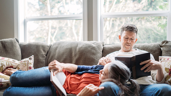 Two people relaxing on a couch in a living room