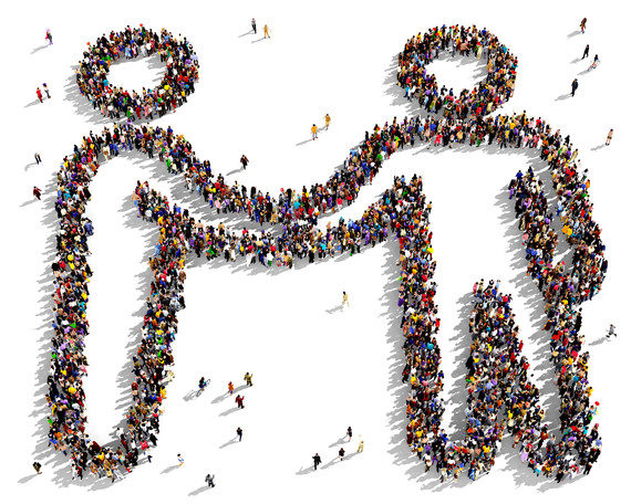 Large group of people seen from above gathered together in the shape of a friendship symbol