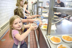 Lyla Moore, 5, picks up a tray at the summer lunch program at the Danville (Pa.) e-Learning Academy building. (Photo by Robert Inglis/The Daily Item)