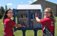 Americorps members in prevention at Positive Alternatives Courtney Wagner, left, and Paige Reed put items into a Blessing Box.