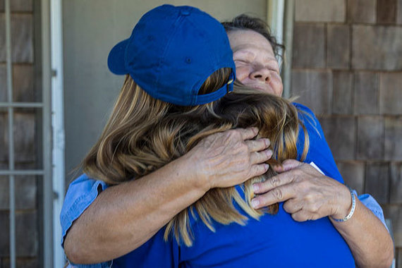 An AmeriCorps NCCC FEMA Corps member receives a hug after providing survivor registration information to a Texas homeowner.