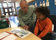 Foster Grandparent Fred Leidel helps a student in a Wisconsin classroom.