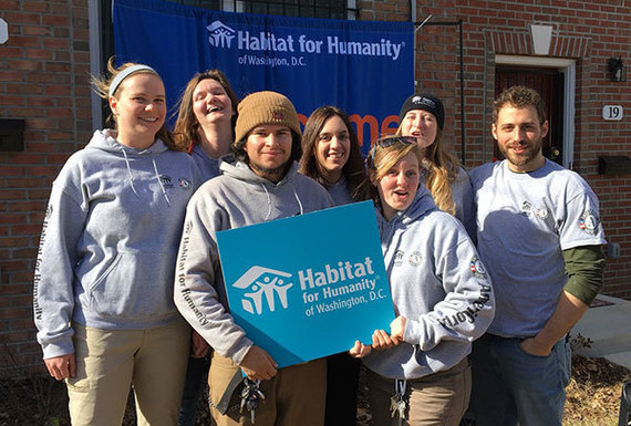 AmeriCorps members with D.C. Habitat for Humanity pose at a home dedication ceremony in the city.