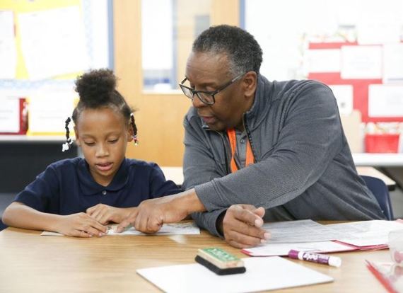 Reading Partner volunteer Will Bruner helps Eugene Field Elementary student Shalese Walker during a tutoring session. (Photo by Ian Maule/Tulsa World)