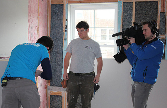 A Hearst Television news photographer films Habitat for Humanity AmeriCorps members in action during a building project in Washington, D.C.