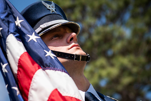 Air Force Senior Airman Craig Jozwiak holds an American flag during groundbreaking for the Intrepid Spirit Center at Eglin Air Force Base, FL.