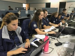 Line of FEMA Corps members working on computers