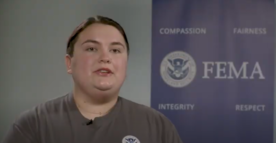 FEMA Corps team leader facing camera with FEMA banner in the background