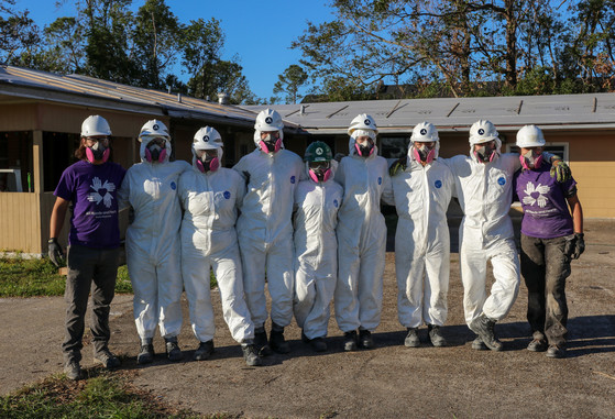 NCCC team posed outside of house together in Tyvek suits