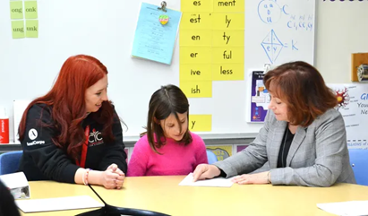 A Colorado second-grader reads with Lt. Gov. Dianne Primavera and her AmeriCorps reading coach.