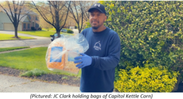 JC Clark holding bags of popcorn