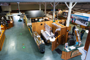 The inside of The Vermont Building showing several wooden stalls and stands.