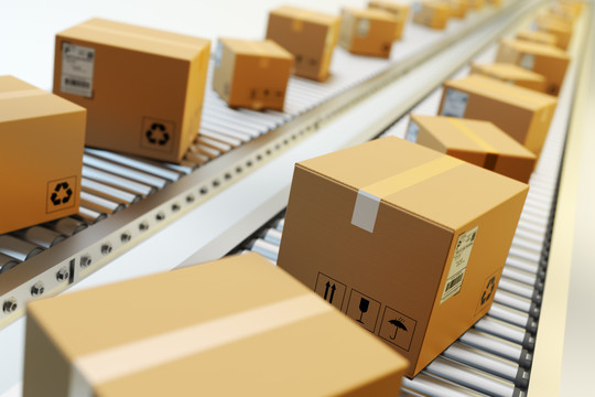 Photo of boxes on a roller conveyor belt in a mail facility.