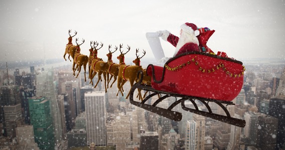 Santa Claus on a sleigh being pulled by reindeer over a city