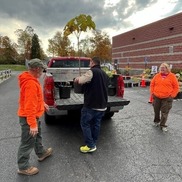 Employees load free tree into resident's vehicle
