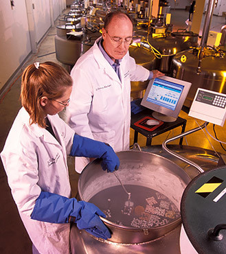 ARS researchers place germplasm samples into a liquid nitrogen tank for long-term storage. 