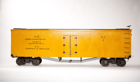 Wood and metal train car model made by the U.S. Department of Agriculture; wood is an orange tint with black lettering