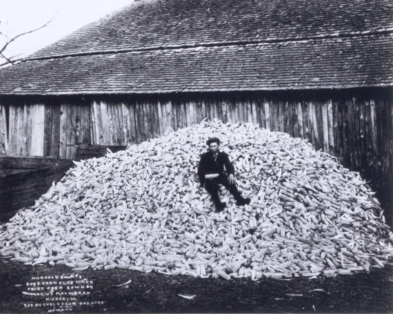 Man sitting in pile of corn cobs