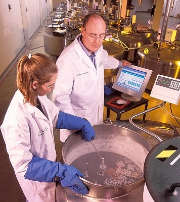 Harvey Blackburn and Ginny Schmit placing animal germplasm samples into a liquid nitrogen tank.