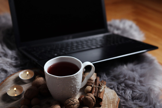 Laptop on table with mug of coffee and winter spices 