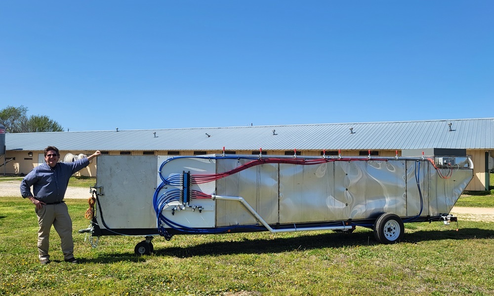 ARS Research Soil Scientist Philip Moore poses next to the indoor air scrubber. (Photo by Jerry Martin, ARS)