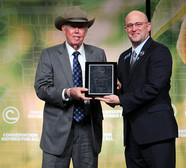 El fundador del Distrito de Conservación de las USVI, Hans Lawaetz, recibe el Premio al Servicio Distinguido del Presidente de NACD, Michael Crowder.