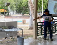 State Soil Scientist Manuel Matos uses rainfall simulator to demonstrate the benefits of soil cover to Ponce summer camp students.