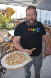 New City Cafe Coordinator Luke De Haan shows an apple dessert pizza about to placed in the cafe's woodburning oven.