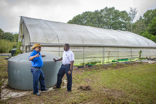 Farmer and USDA employee in front of high tunnel