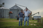 men in front of grain bins