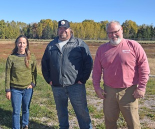 NRCS and Sault Tribe Fisheries staff stand in front of the tribe's whitefish rearing pond.