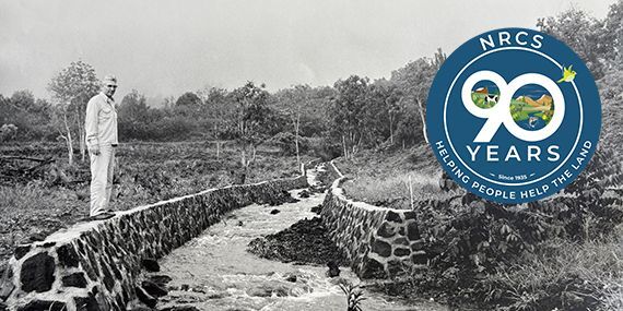 Historical photo of a man standing by a river.