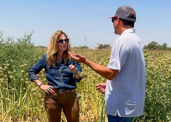NRCS Chief Aubrey Bettencourt speaking with a producer in a field of plants