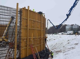 Workers fill a form with concrete to make part of a wall for an anaerobic digester at a dairy farm in Ionia County.