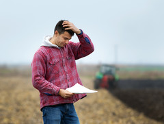 A young, worried farmer feels the weight of managing a farm. FRSAN can help farmers deal with farming pressures. Image courtesy of Getty Images.