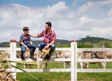 Photo of father and son at dairy farm, courtesy of Getty Images
