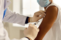Closeup of doctor giving a vaccine, image courtesy of Getty Images.
