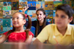 Young girl asking a question at school, courtesy of Adobe Stock.