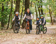 Family bike riding in a forest, courtesy of Adobe Stock.