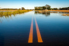 Flooded road and fields, courtesy of Adobe stock.