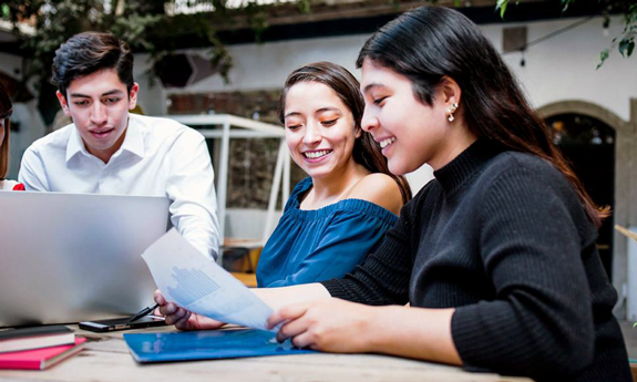 College students working at table together, courtesy of Adobe Stock.
