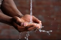 Water pouring into hands. Image courtesy of Adobe Stock.