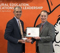 Dr. Shane Robinson presents the 2025 Distinguished Alumni in Agricultural Education Award to Dr. Hamby.