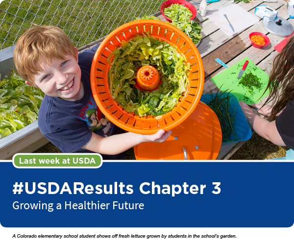 A Colorado elementary school student shows off fresh lettuce grown by students in the school&rsquo;s garden.