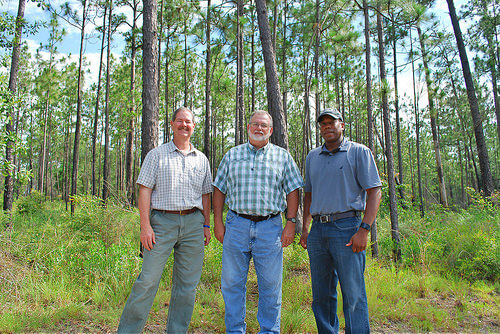 Jimmy Bullock with the Resource Management Service, Andrew Schock with The Conservation Fund and NRCS Alabama State Conservationist Ben Malone stand i
