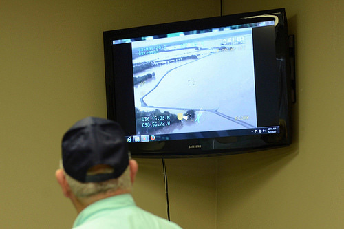 Secretary Perdue watching a monitor showing flood damage