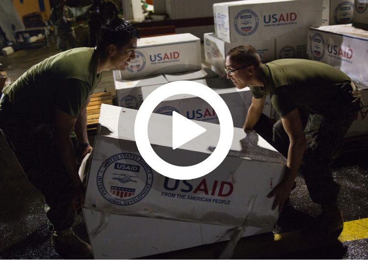 U.S. Marines with Joint Task Force - Leeward Islands stack boxes of tarps from the U.S. Agency for International Development as they prepare supplies 