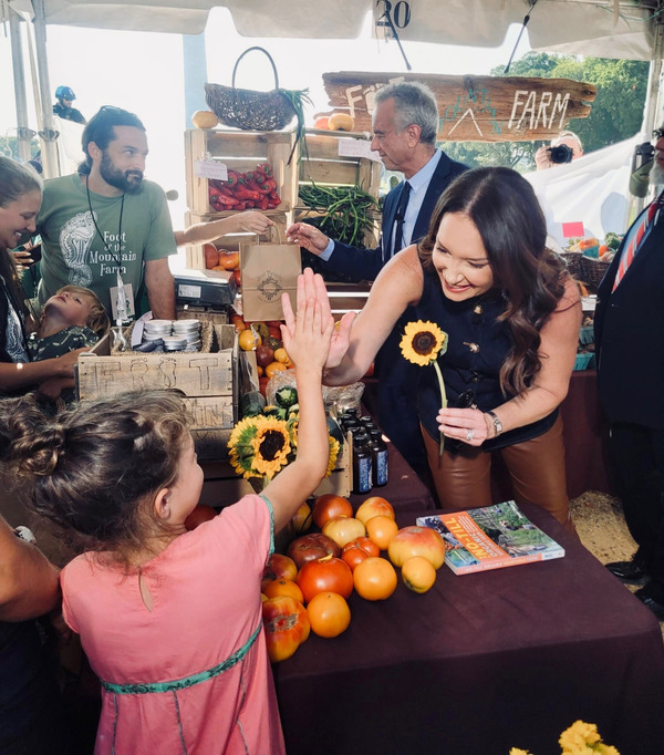 Secretary Rollins giving a high five to a girl at the farmers market