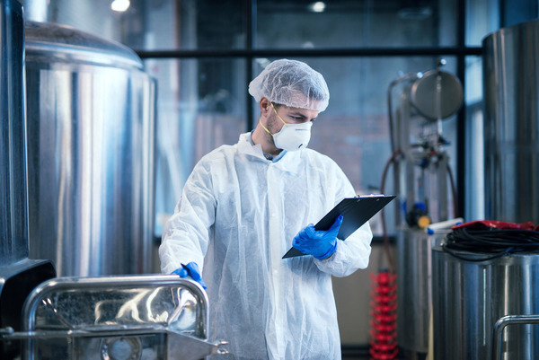 Technologist working in food processing factory checking quality and production