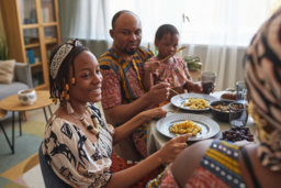 Black family seated at a table eating dinner
